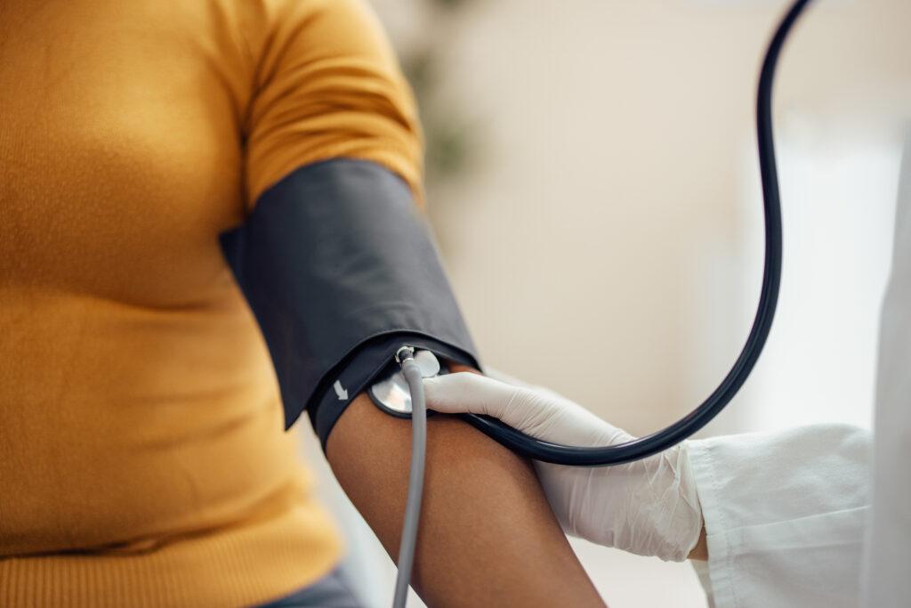 Doctor checking the blood pressure on a patient with a blood pressure cuff
